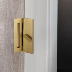 a close up of a door handle on a white and gold door with wood paneling