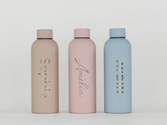 three different types of water bottles are shown in front of a white background and one is pink, the other blue