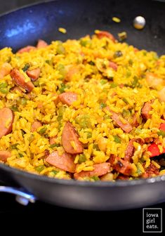 a skillet filled with rice and sausages on top of a stove burner