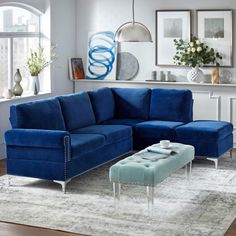 a living room with blue couches and white rugs on the floor in front of windows