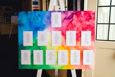 a multicolored canvas with seating cards attached to it