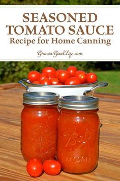 two mason jars filled with tomatoes sitting on top of a wooden table next to a sign that says seasoned tomato sauce recipe for home canning