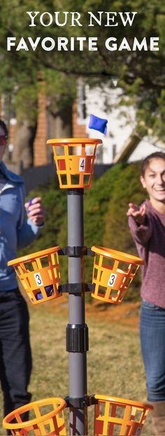 two people are playing with their new favorite game, the basket tosser and it's tower