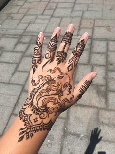 a woman's hand with henna tattoos on it