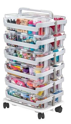 a stack of plastic containers on wheels with lots of different items in them, all stacked together