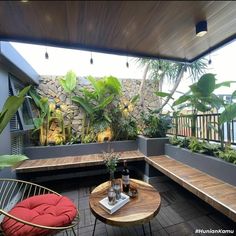 a wooden bench sitting on top of a hard wood floor next to a plant filled wall