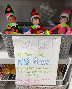 two elfs sitting on top of a shelf next to a sign that says, oh no we have the elf pox this happens sometimes when we eat from muffins candy