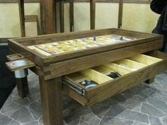 a wooden table with drawers underneath it and a person standing in front of the table