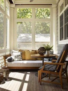 the sun shines through the large windows in this porch with white walls and wood flooring