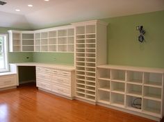 an empty room with white bookcases and wooden floors