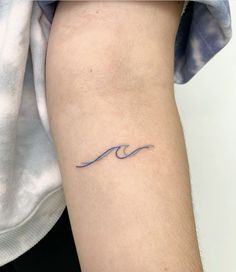 a person with a small wave tattoo on their arm