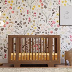 a baby crib in front of a floral wallpaper