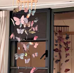 a window with butterflies hanging from it's side