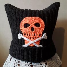 a crocheted pillow with a skull and crossbones on the front is shown