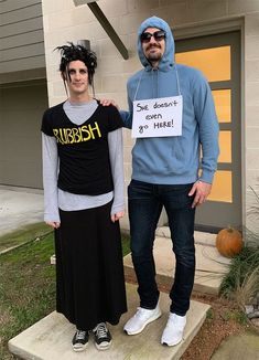 two people dressed in costumes standing next to each other on the steps outside of a house