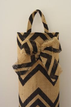 a black and white chevron bag with a bow on the front, sitting against a wall