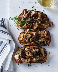 three pieces of bread with mushrooms and herbs on top