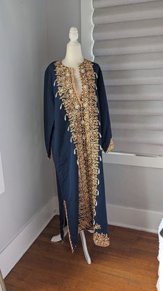 "Gorgeous Egyptian blue cotton women's formal kaftan dress Made in Egypt Embellished with peach colored trim, gold sequins, and faux pearls, all sewn on by hand. There is no size The dress measures 16\" across the top of the shoulders, 23\" sleeves, 23\" across flat between the armpits, 52\" long. Both slits on sides are 14\" long up from the hemline. It is in excellent condition and is truly a unique, handmade vintage item" Hand Embellished Gold Dresses For Eid, Gold Hand Embellished Dress For Eid, Elegant Dresses With Pearl Embroidery For Festivals, Bollywood Style Long Sleeve Dress With Pearl Embroidery, Gold Embellished Kurta For Festivals, Gold Long Sleeve Thobe For Festive Occasions, Bollywood Long Sleeve Dresses With Pearl Embroidery, Gold Embellished Kurta For Party, Gold Dresses With Dabka Work