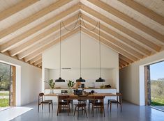 an open living room and dining area with wood beams on the ceiling is shown in this image