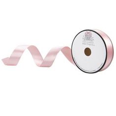 a roll of pink satin ribbon on a white background