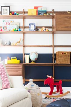 a child's playroom with toys and bookshelves on the wall, including a rocking horse