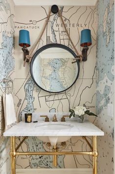 a bathroom with a sink, mirror and wallpapered walls in the background that has blue lamps on it