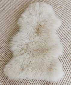 a white sheepskin rug is laying on the floor