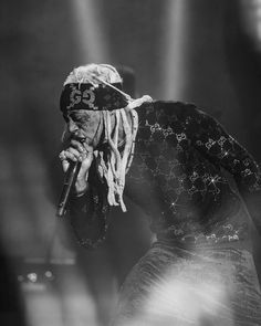 a man with dreadlocks on his head holding a microphone