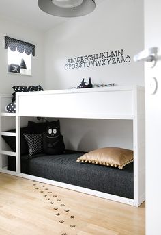 a white bunk bed sitting in a bedroom next to a cat paw print on the floor