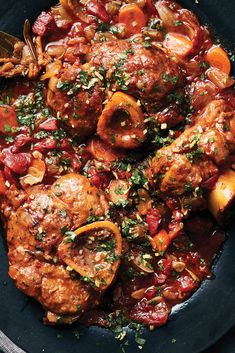 a skillet filled with meat and vegetables covered in sauce