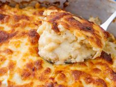 a close up of a casserole in a pan with a spoon on it