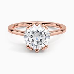 a rose gold engagement ring with an oval cut diamond in the center and two rows of round