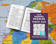 the sudoku puzzles travel size book is open on a world map and it's contents are visible