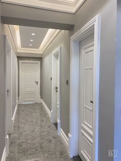 an empty hallway with two doors leading to another room in the same direction and light fixtures on either side