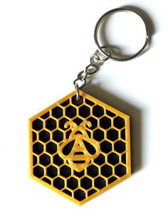 a wooden keychain with a bee on it