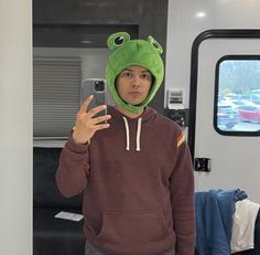 a person wearing a frog hat taking a selfie