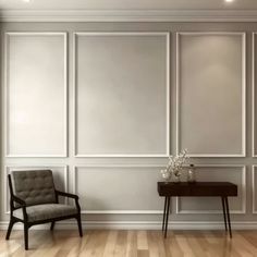 an empty room with a chair, table and vase on the floor in front of white paneled walls