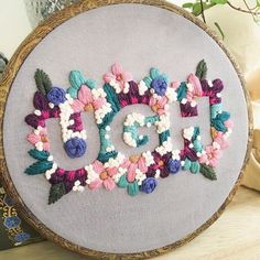 an embroidery project is being displayed on a cell phone screen, with the word diy spelled in flowers