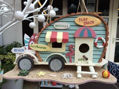 a toy beach hut is hanging from a tree