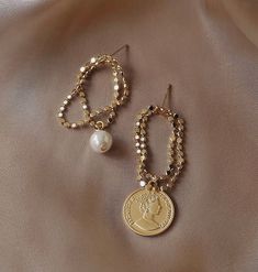 Our newest design gold coin earrings will be a perfect addition to your everyday chic jewelry collection. Delicate 14K gold roman coin medal charm with gold chain loop tassel, mismatched with round pearl drop dangle, unique stylist fashion. One of the kind dainty jewelry to elevate your edgy looks! 💎 Features: ♥ Handmade Jewelry ♥ Material: Finest 14K Gold plated ♥ Main stone: Cultured ivory pearl ♥ Mismatched Design ♥ Screw back closure 💎 Details: ♥ Approximate Measurements: - Length: 20mm - Width: 7mm ♥ Lightweight, easy to wear ♥ Nickel/Lead Free, Hypoallergenic, good for sensitive skins 🎁 Packing & Shipping: ♥ All our jewelry will be shipped with beautiful gift wrap packaging ♥ Handwrite gift notes/cards available upon request ♥ SAME DAY& FREE US Domestic Shipping available ♥ Intern Gold Coin Earrings, Gold Coin Jewelry, Edgy Looks, Stylist Fashion, Earrings Everyday, Chain Loop, Roman Coins, Coin Earrings, Coin Pearls