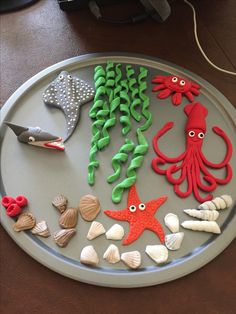 there are many different sea creatures on the plate and one is made out of clay