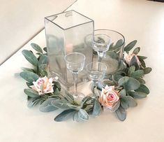 a table topped with glasses and flowers on top of it