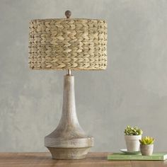 a wooden table with a lamp and potted succulents next to it