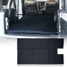 the interior of a white van with black seats and floor mats in front of it