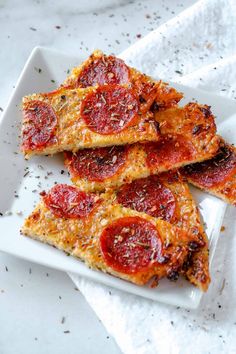 three slices of pepperoni pizza on a white plate