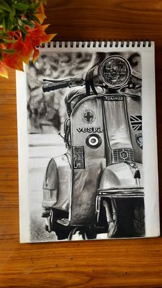 a black and white photo of a motor scooter on a wooden table next to a potted plant