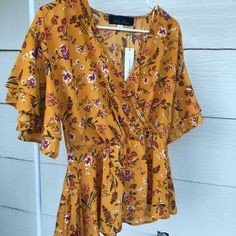 Good Quality, Flowy, Brand New , Never Worn, Has A Waist Belt , Low Cut Fits Like A Medium Chic Printed Yellow Tops, Chic Yellow Printed Top, Mustard V-neck Beach Top, Fitted Yellow Printed Blouse, Yellow Printed Blouse For Summer, Yellow Floral Print V-neck Blouse, Yellow V-neck Blouse With Floral Print, Yellow Printed Blouse For Day Out, Mustard V-neck Top For Beach