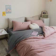 a bed with pink and grey sheets in a bedroom