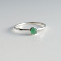 A petite, 4mm green aventurine cabochon has been bezel set in a handmade ring of sterling silver.  These beautiful green aventurine stones have lovely soft shading that make this ring a popular favourite.  Perfect on its own or as an addition to your pile of stacking rings.  So cute as a midi ring! Common midi ring (above the knuckle ring) sizes are 3, 3.5 and 4 but it is always best to be sized for certainty. The final picture shows the ring band styles. The ring pictured has a smooth band, but I can make this ring with any band you choose.  Available in size 2, size 2.5, size 3, size 3.5, size 4, size 4.5, size 5, size 5.5, size 6, size 6.5, size 7, size 7.5, size 8, size 8.5, size 9, size 9.5, size 10, size 10.5, size 11, size 11.5, size 12, size 12.5, size 13 Everyday Green Gemstone Stackable Rings, Everyday Green Stackable Rings With Bezel Setting, Green Minimalist Stackable Rings With Bezel Setting, Minimalist Green Stackable Rings With Bezel Setting, Soft Shading, Ring Green Stone, Aventurine Ring, Green Stone Ring, Green Aventurine Stone