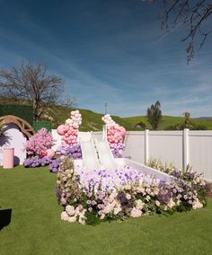 an artificial flower garden with pink and white flowers in the shape of a slide is shown